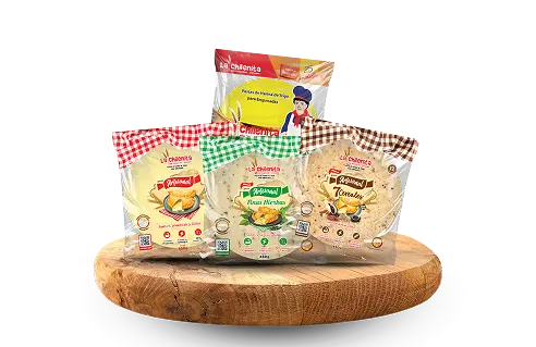 Bodegón con packs de productos La Chilenita sobre base de madera, incluyendo variedades artesanales de empanadas y tortillas.